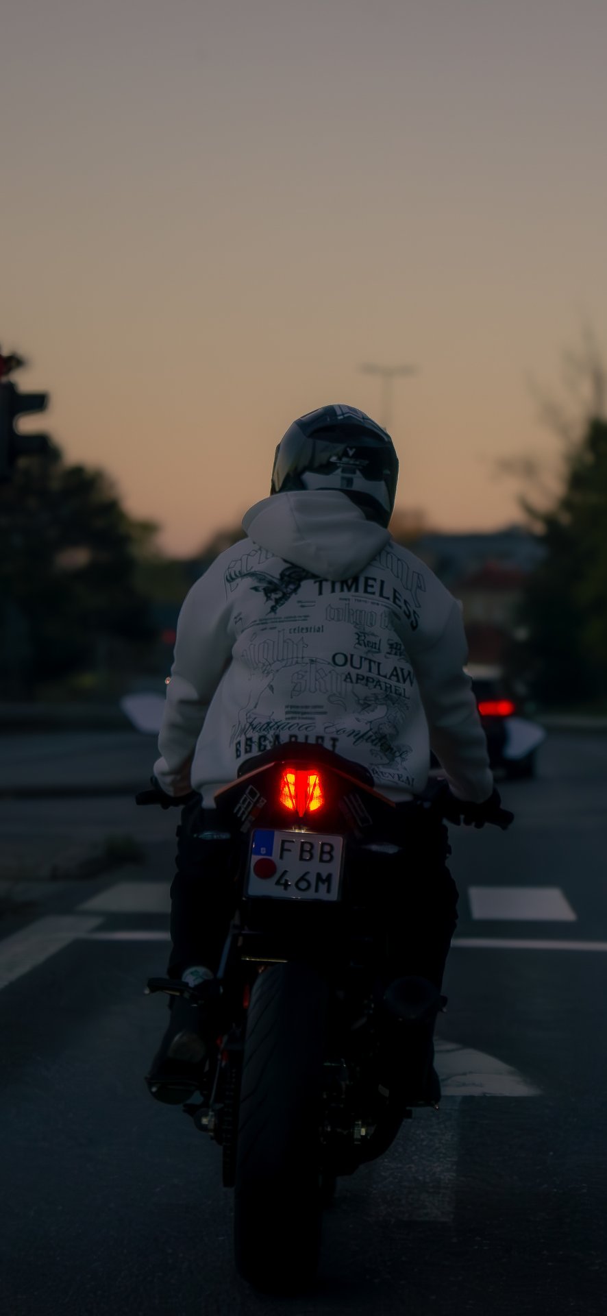 Motorcyklist bakifrån i skymning
